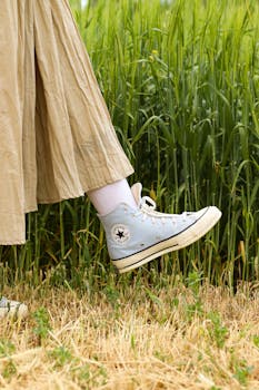 Close-up of a sneaker in a grassy field, capturing a casual outdoor vibe.