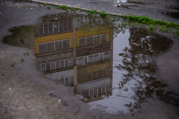Reflection of Orange Building in Puddle on Urban Street · Free Stock Photo