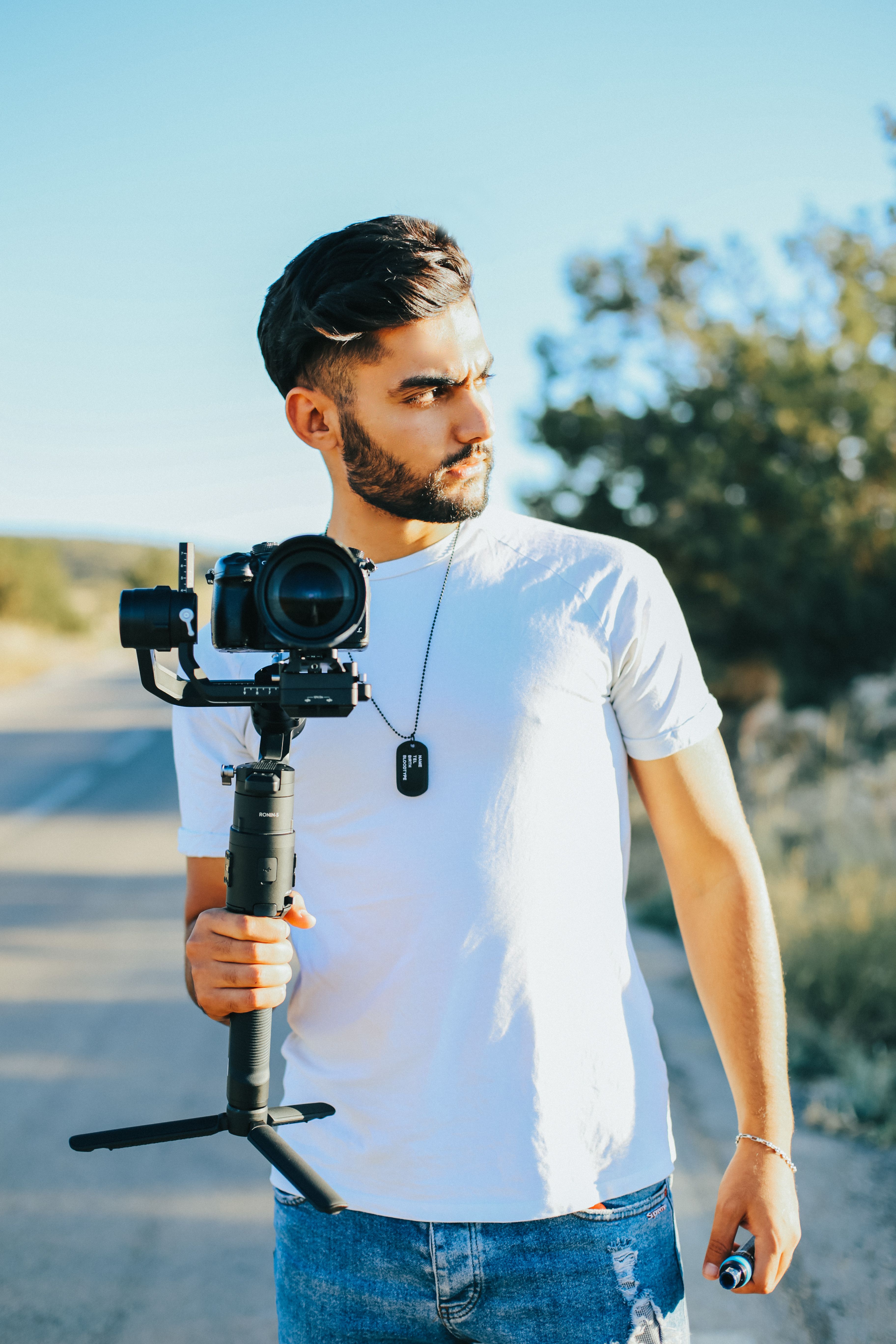 Man Holding Black Dslr Camera With Stabilizer · Free Stock Photo