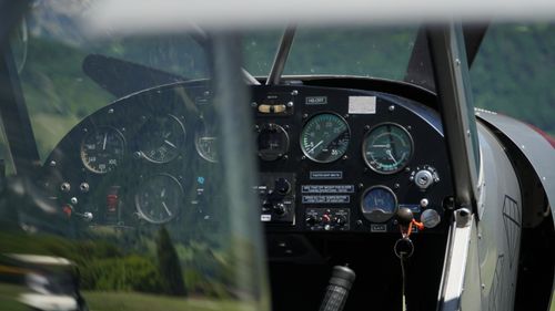 Free Detailed view of a vintage aircraft cockpit's instrument panel surrounded by nature. Stock Photo
