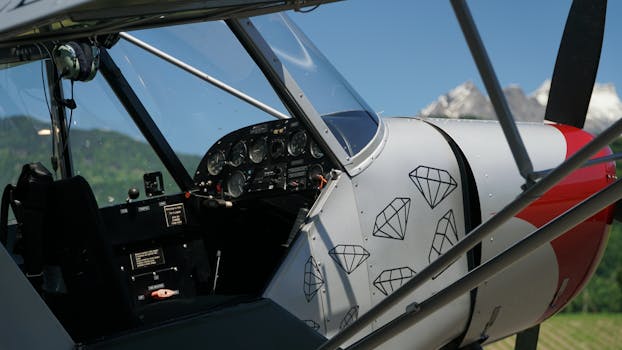 Close-up of vintage airplane cockpit with mountain backdrop, diamond design on exterior.