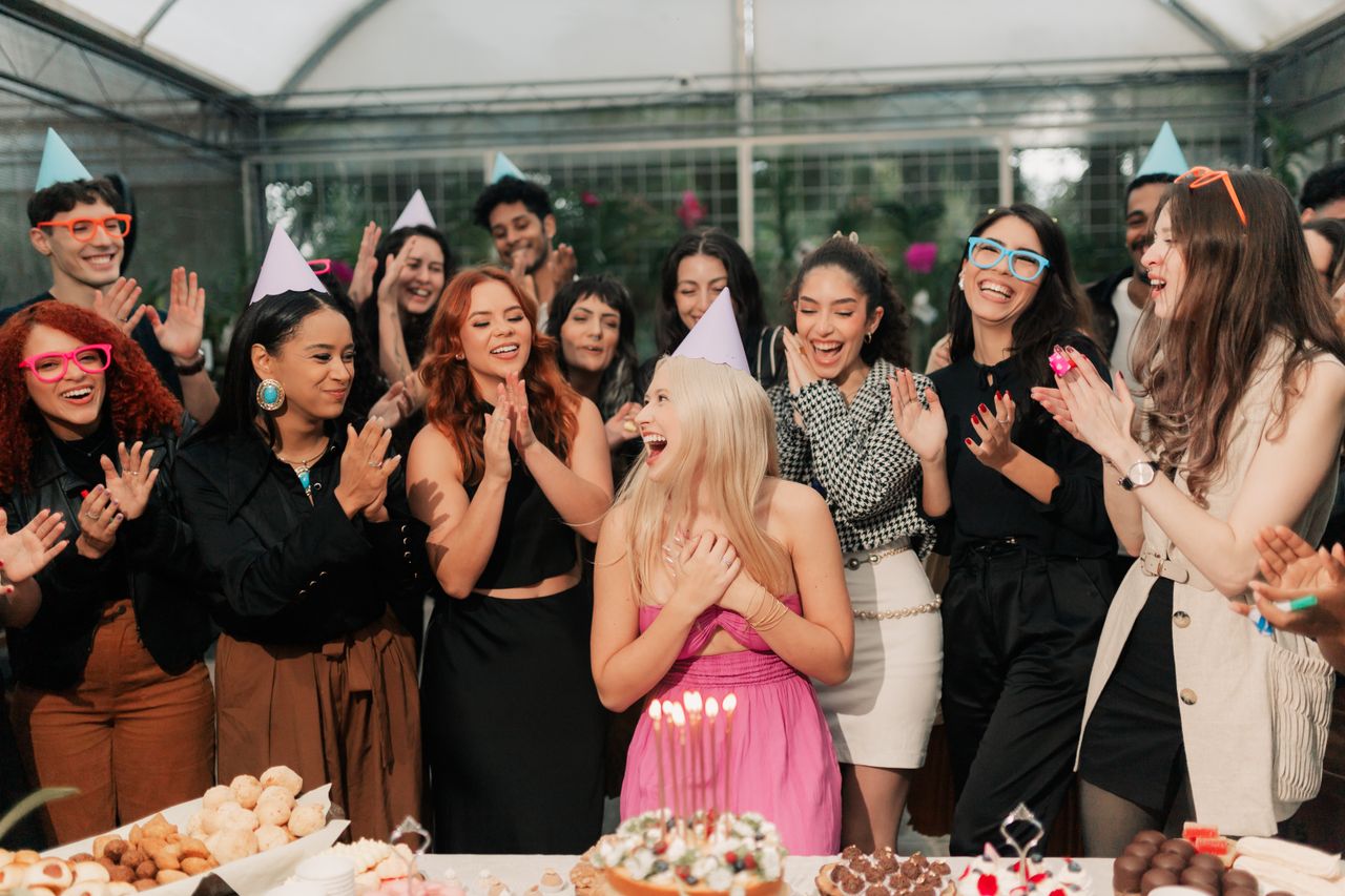 a group of friends joyfully celebrating a birthday party indoors with