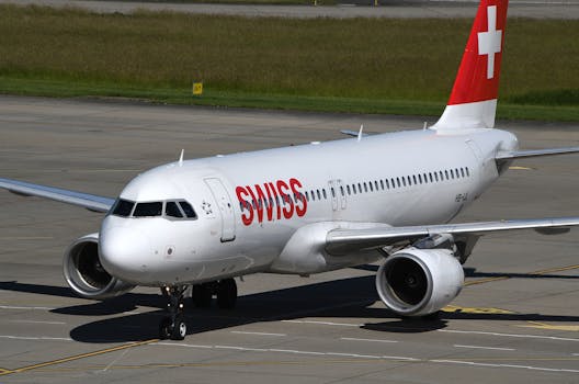 Swiss aircraft taxiing on the runway at Geneva Airport, showcasing its distinctive livery.