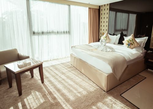 Free Spacious hotel room with large bed, elegant decor, and natural light in Baghdad, Iraq. Stock Photo