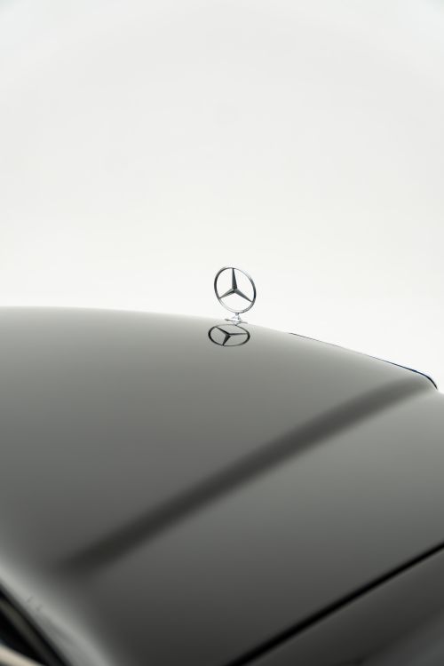 Free Elegant black Mercedes-Benz hood ornament detail against a white background. Stock Photo