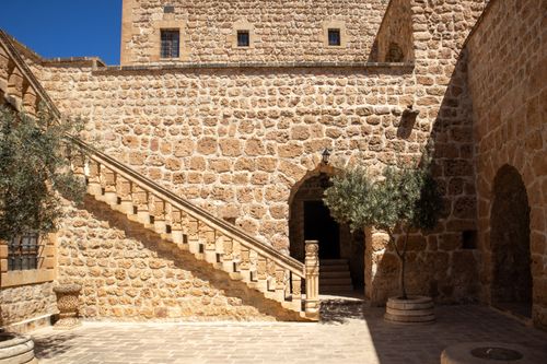 Free Intricate stone architecture with staircase in historic Mardin, Türkiye. Rich heritage in sunlight. Stock Photo