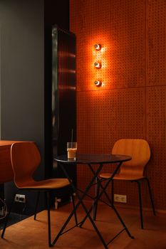 Warm cozy corner of a café with wooden chairs and stylish lights.
