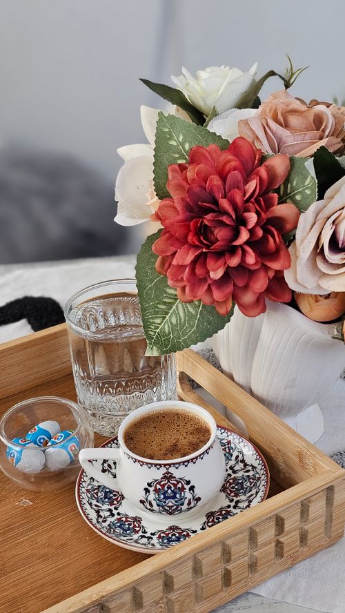 Free Sophisticated coffee setup on a wooden tray with ornate cup and floral arrangement. Stock Photo