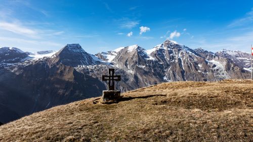 Free Scenic view of the Austrian Alps in Kärnten with a wooden cross monument on a grassy hill. Stock Photo