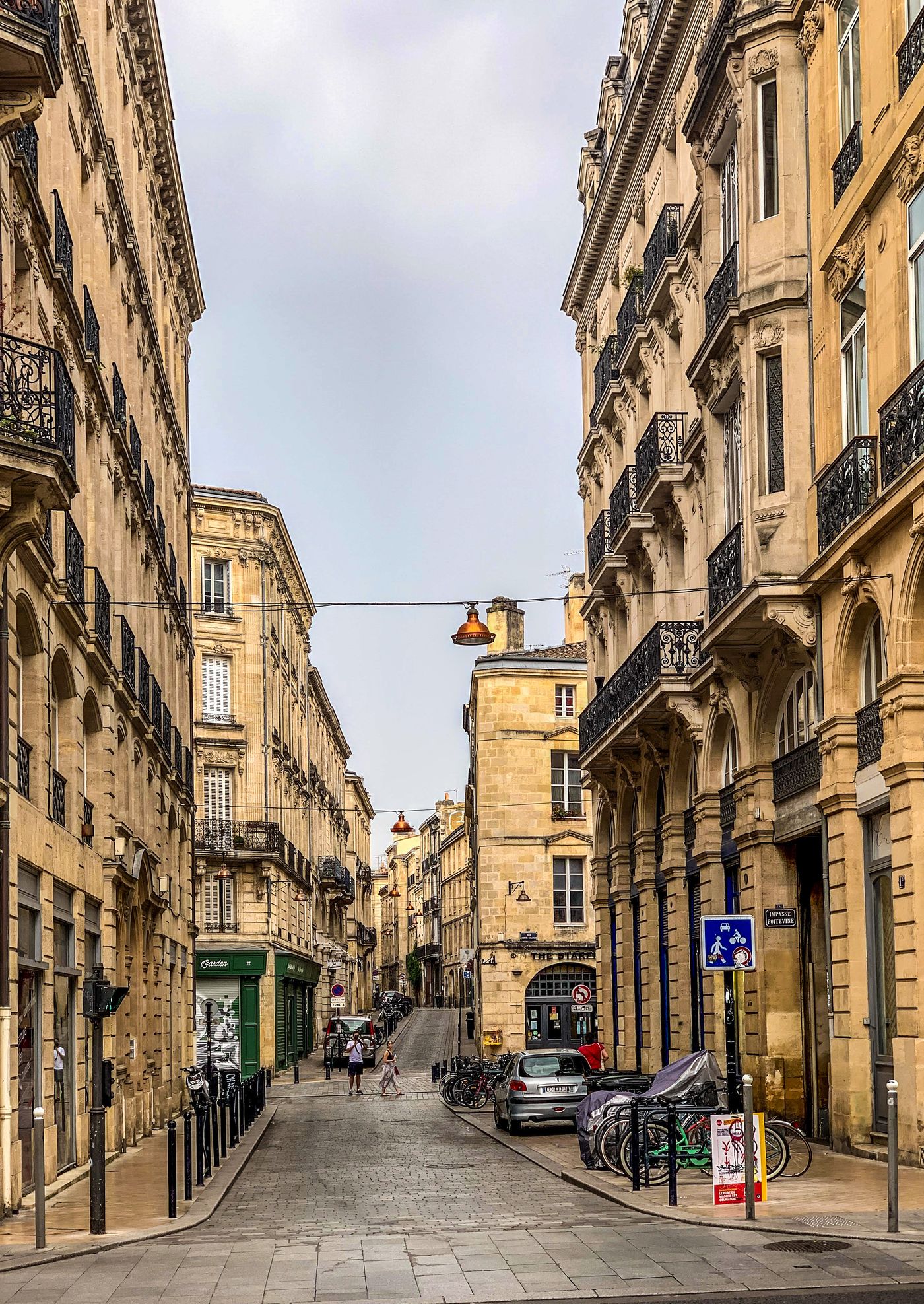 Une rue pavée de Bordeaux bordée d'immeubles anciens en pierre