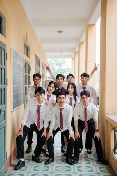 A group of students in school uniforms posing in a corridor, showcasing youthful camaraderie.