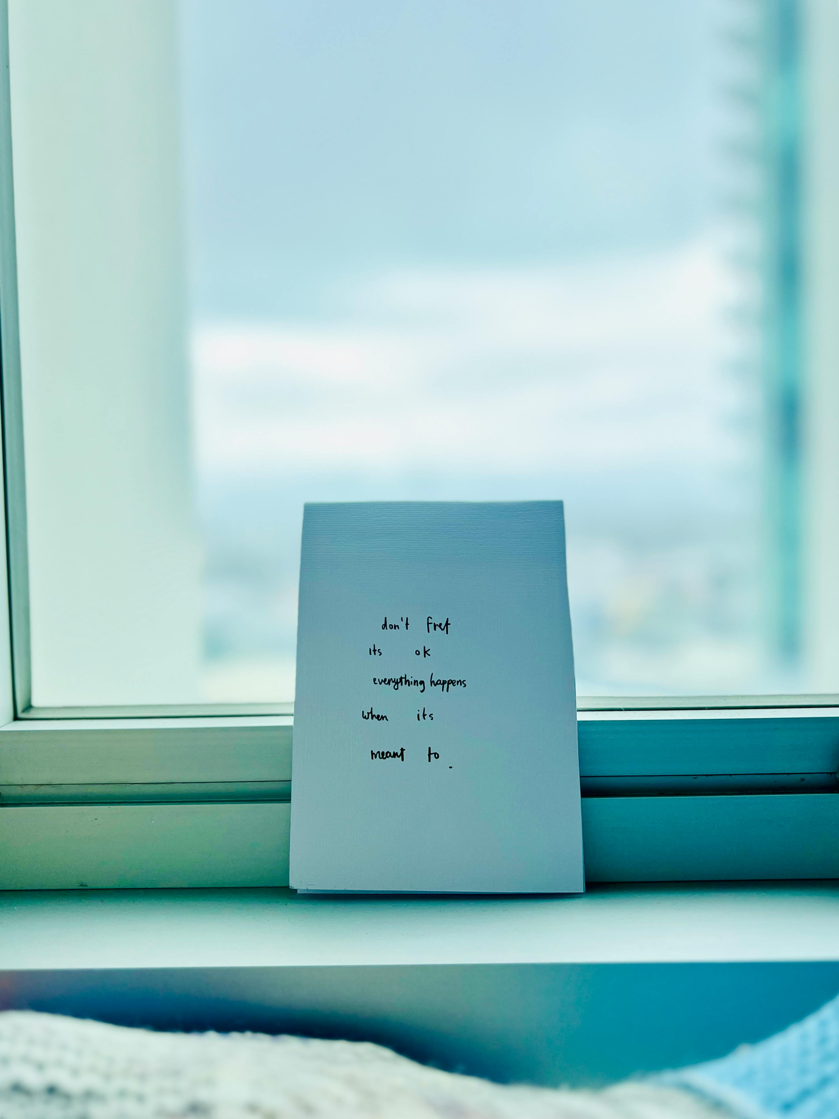 Zadarmo Motivačná citátová karta umiestnená na parapete s rozmazaným výhľadom na panorámu mesta. Fotka z fotobanky