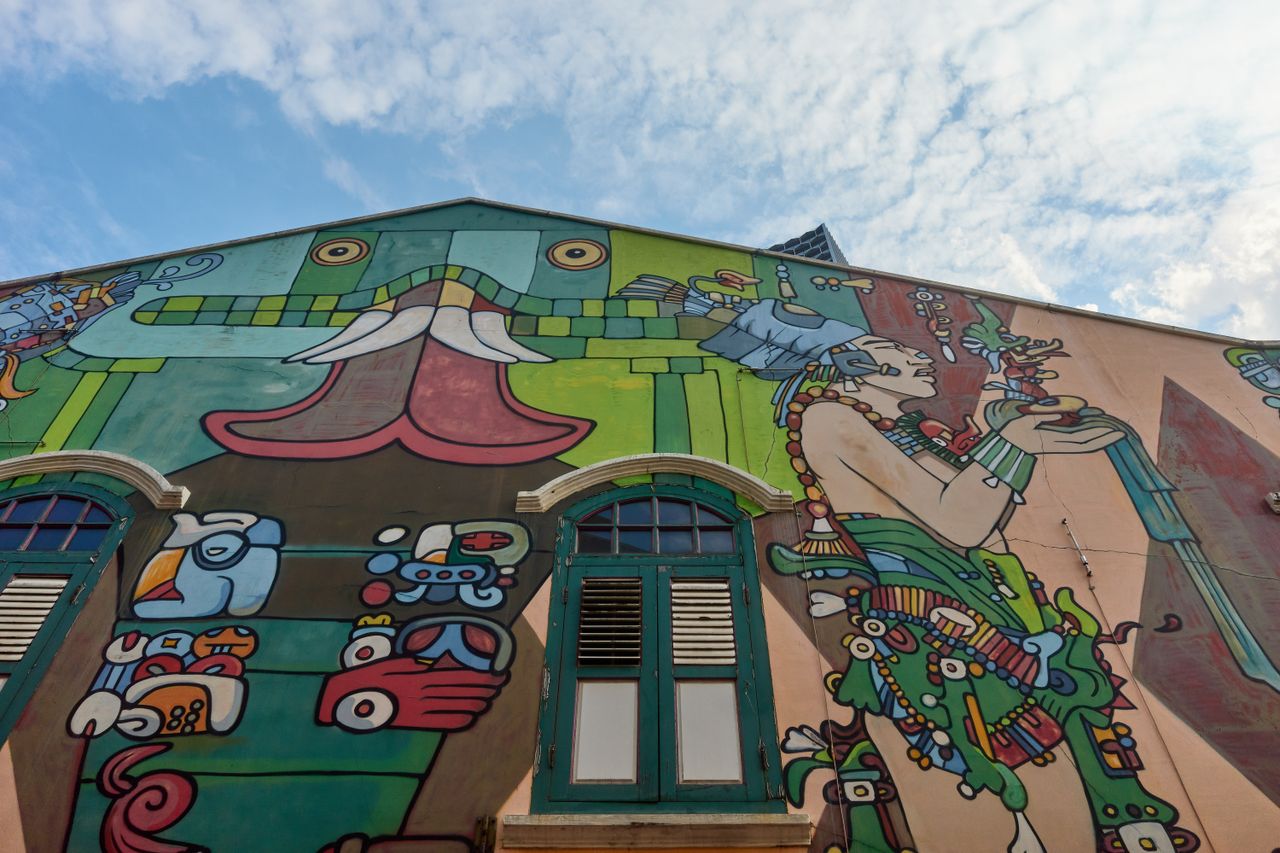 colorful mural featuring indigenous motifs on a building facade under
