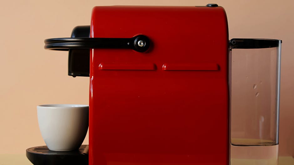 Nespresso Vertuo vs Keurig K-Supreme: Single-Serve Coffee Convenience and Taste Compared Red coffee machine with a white ceramic mug, ideal for coffee lovers and modern kitchens.
