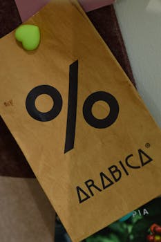 A close-up view of a % Arabica coffee shop sign pinned with a heart-shaped magnet.
