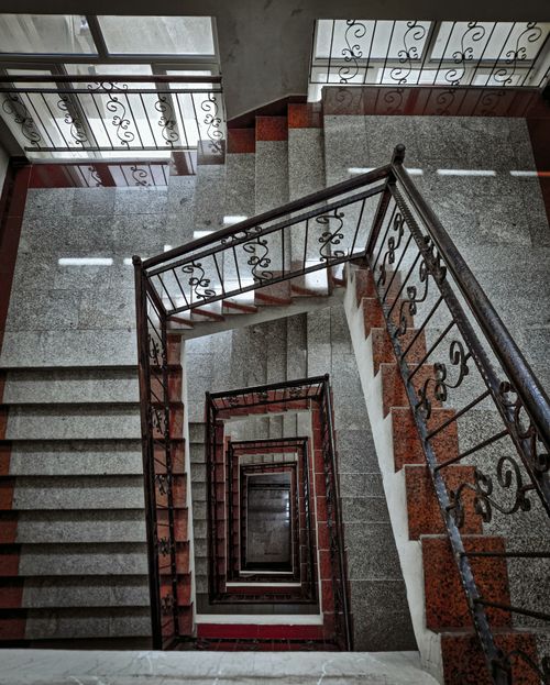 Free A top view of an elegant spiral staircase with wrought iron railings and granite steps. Stock Photo