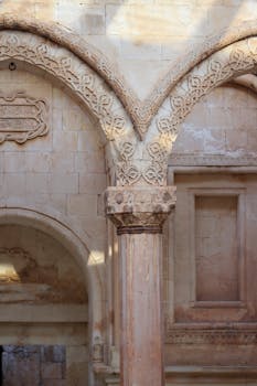 Detailed view of a historical stone archway with ornate carvings and classical design elements.
