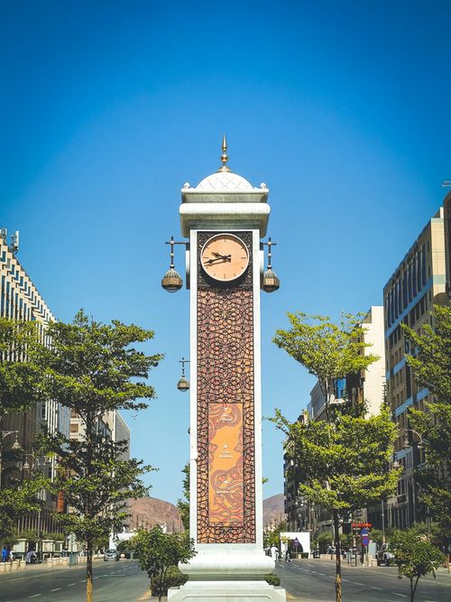 Free Beautiful clock tower on a sunny day in a bustling city street. Stock Photo
