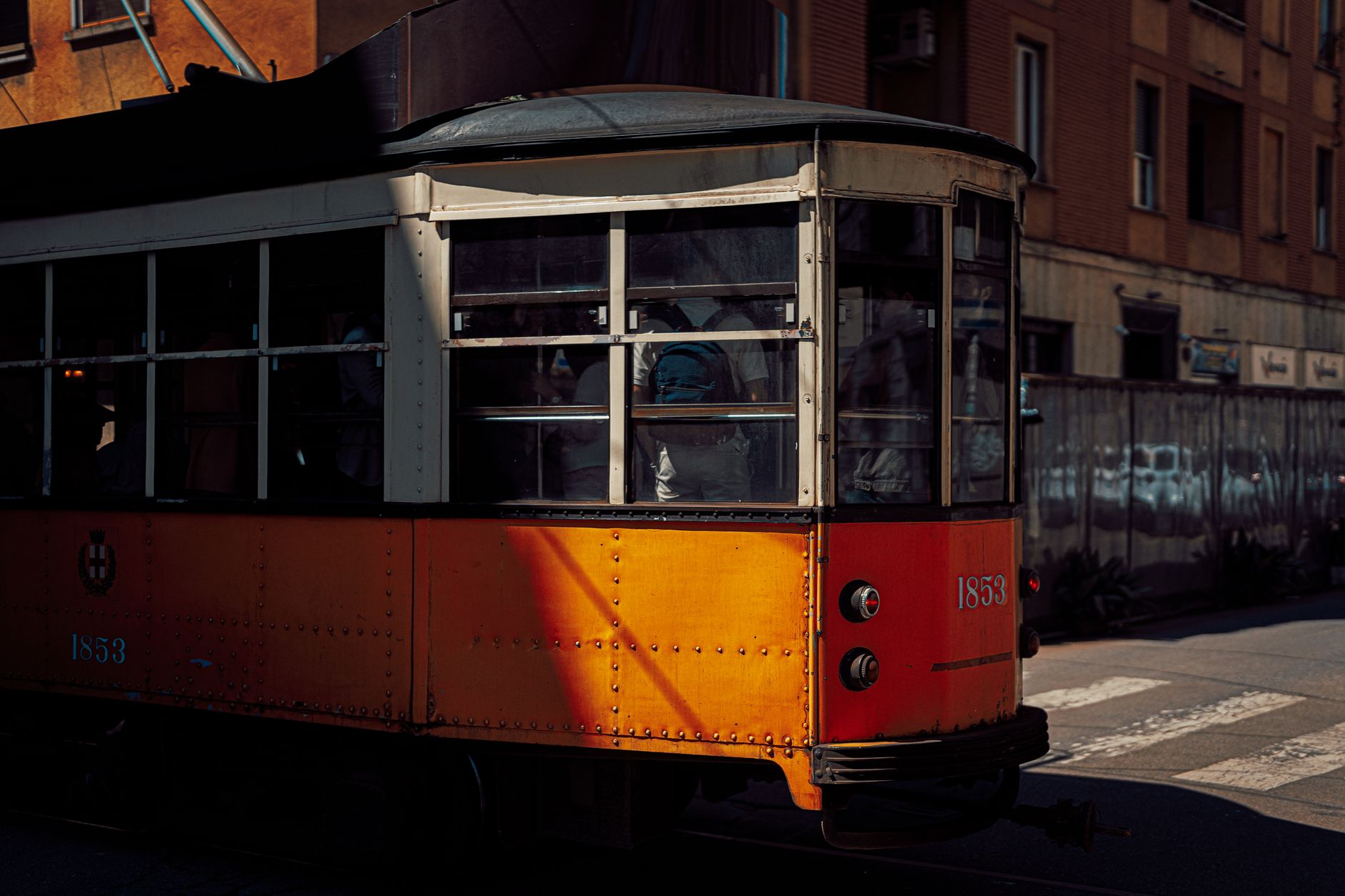 Iconic vintage orange tram captured on a sunny day in Milan, Italy.