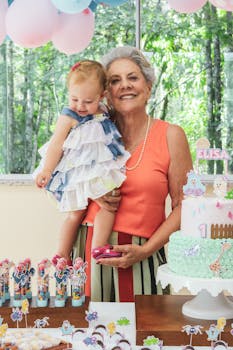 祖母抱着婴儿，参加了配有蛋糕和装饰品的色彩缤纷的生日派对