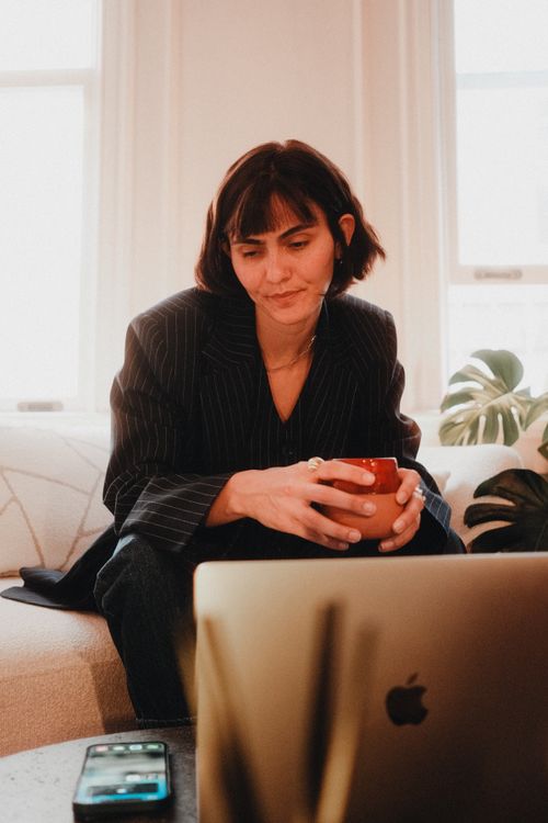 Free Relaxed businesswoman with coffee mug working from home office. Stock Photo
