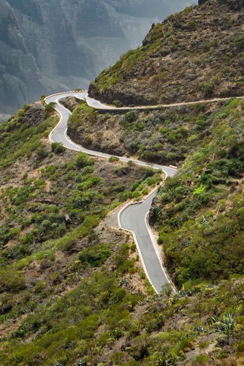Free Aerial view of a winding road through rugged mountain landscape, perfect for road adventure. Stock Photo