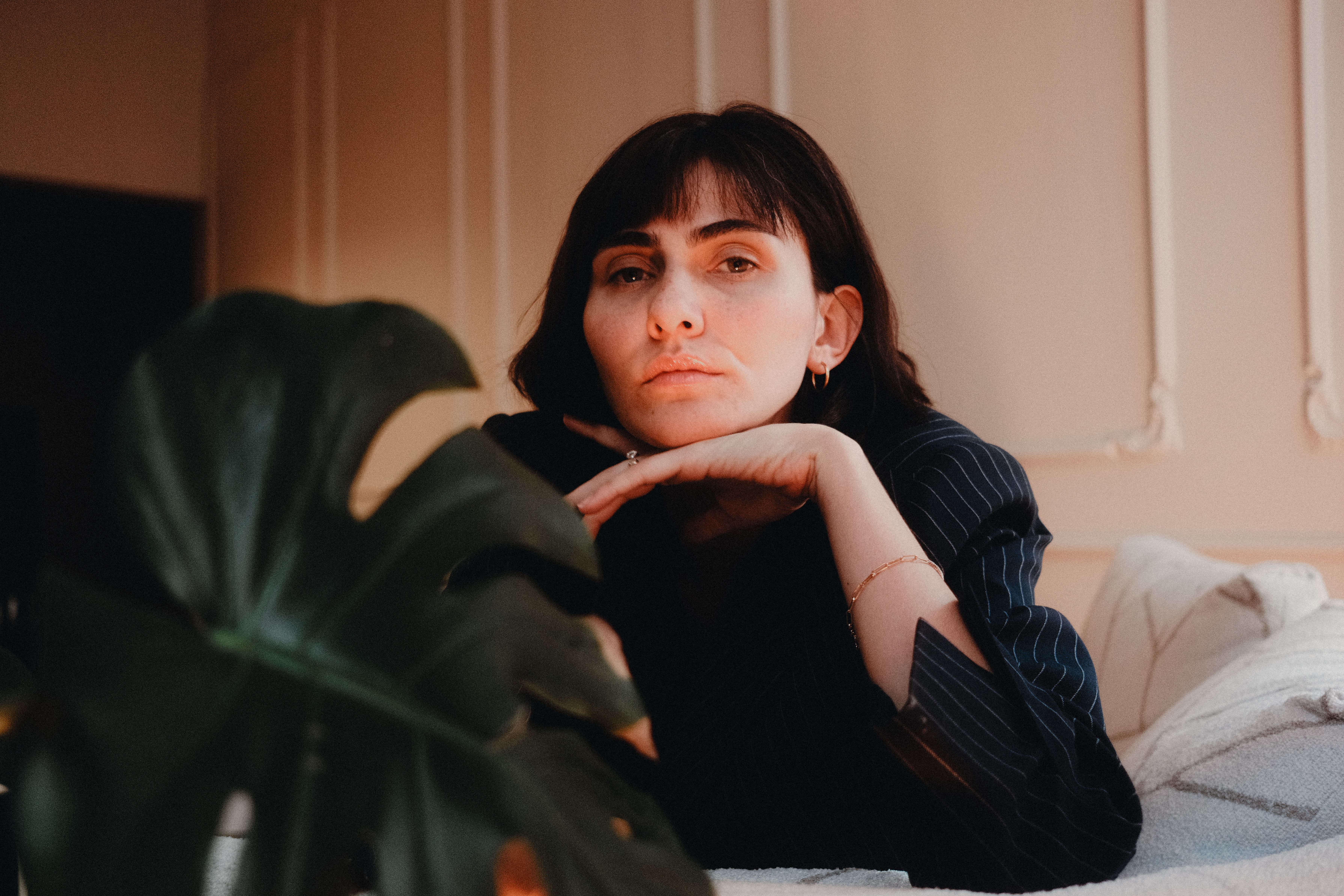 Nonbinary person in their forties sitting calmly at home in soft natural light