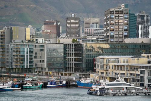 Free A vibrant waterfront cityscape with modern buildings and docked boats. Stock Photo