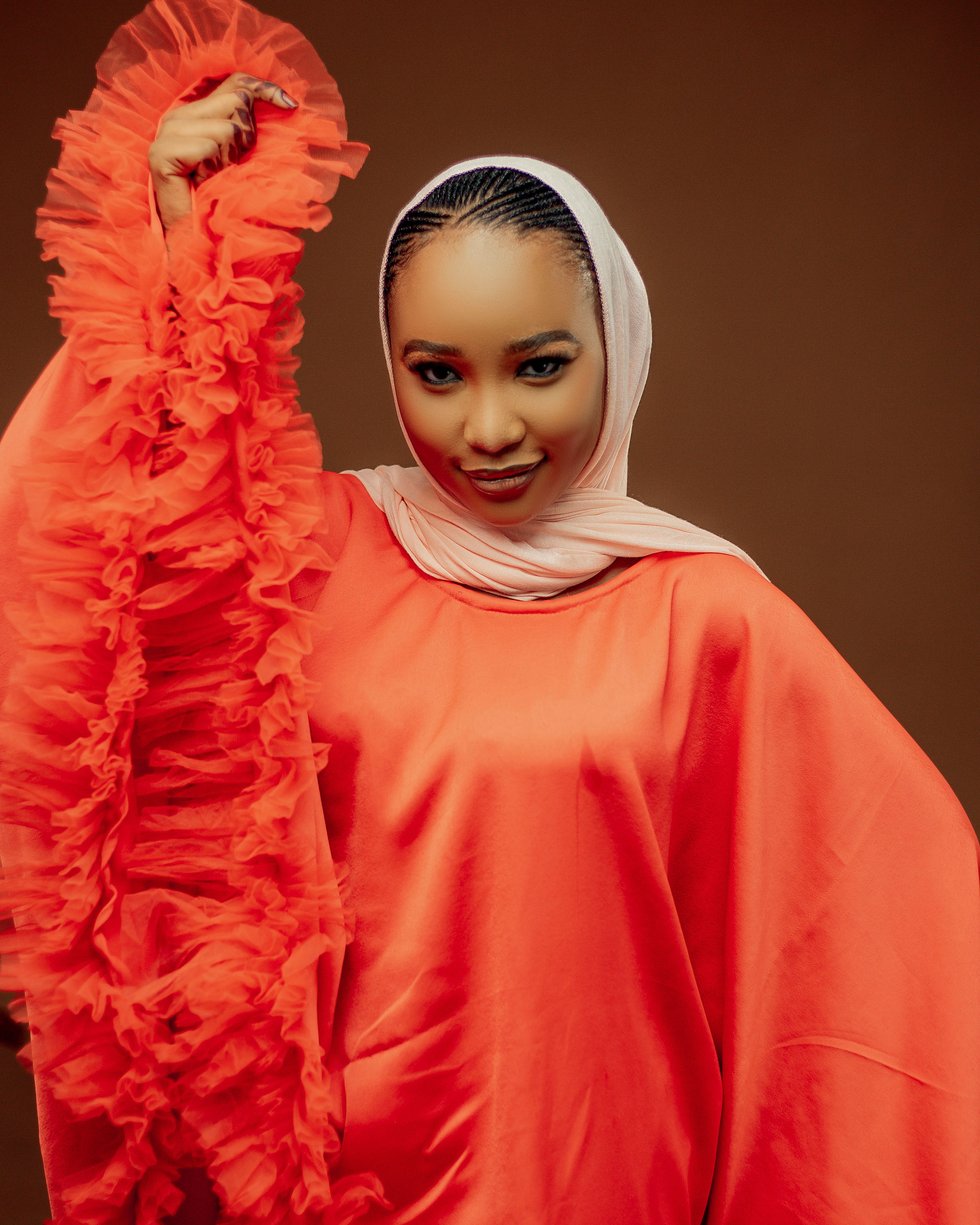 Portrait of a woman in colorful traditional attire with a confident expression.