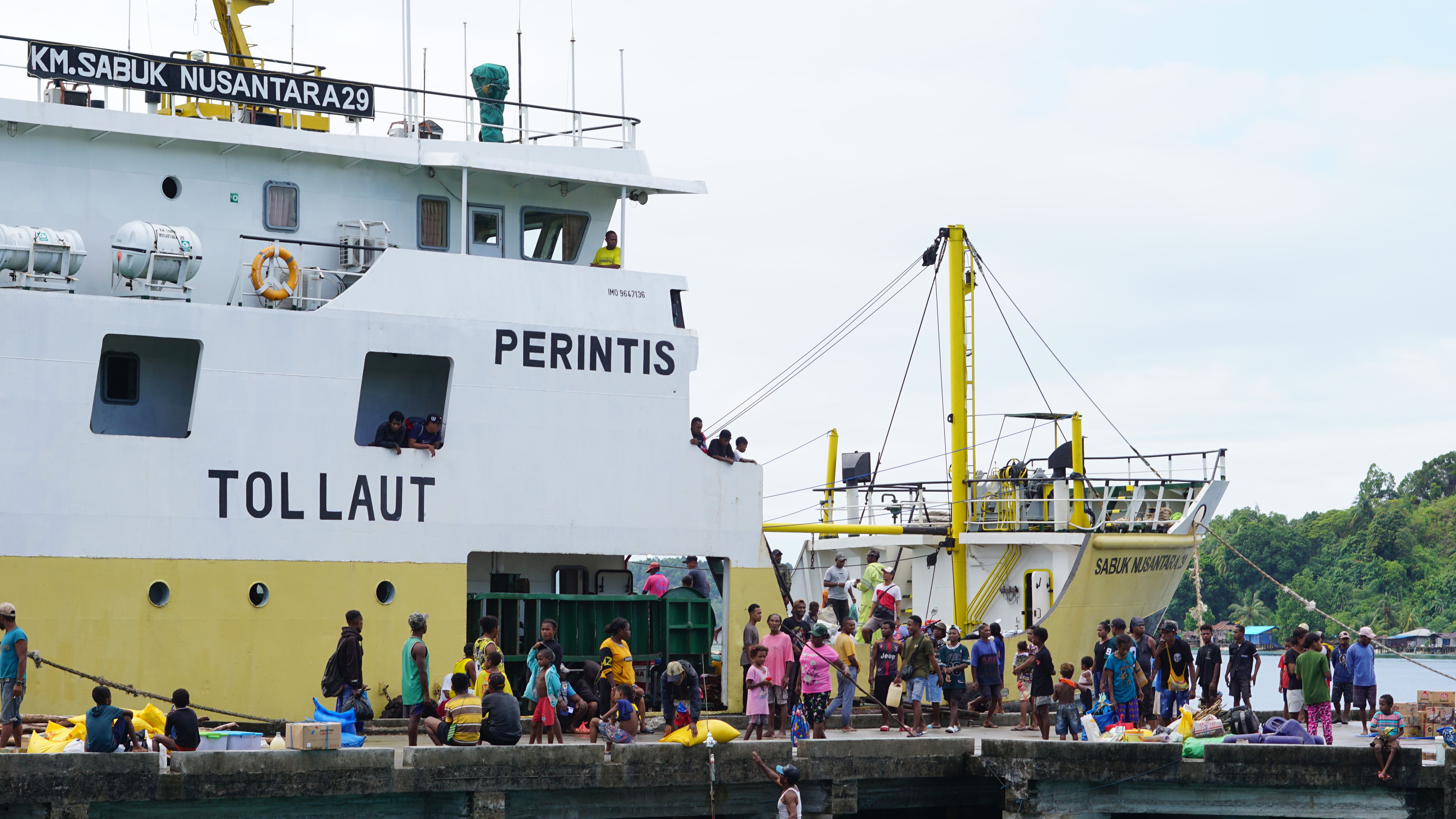 Vibrant harbor activity with local people and boats in Papua, Indonesia.