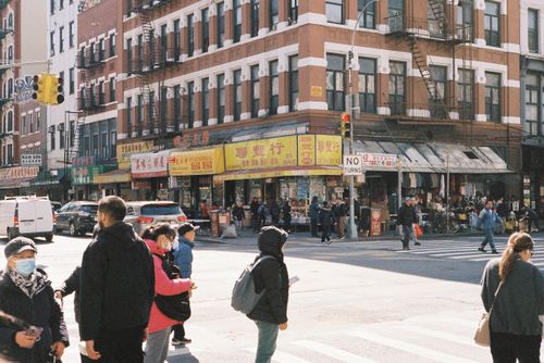 Free Crowded street corner in Chinatown with pedestrians and shops on a sunny day. Stock Photo
