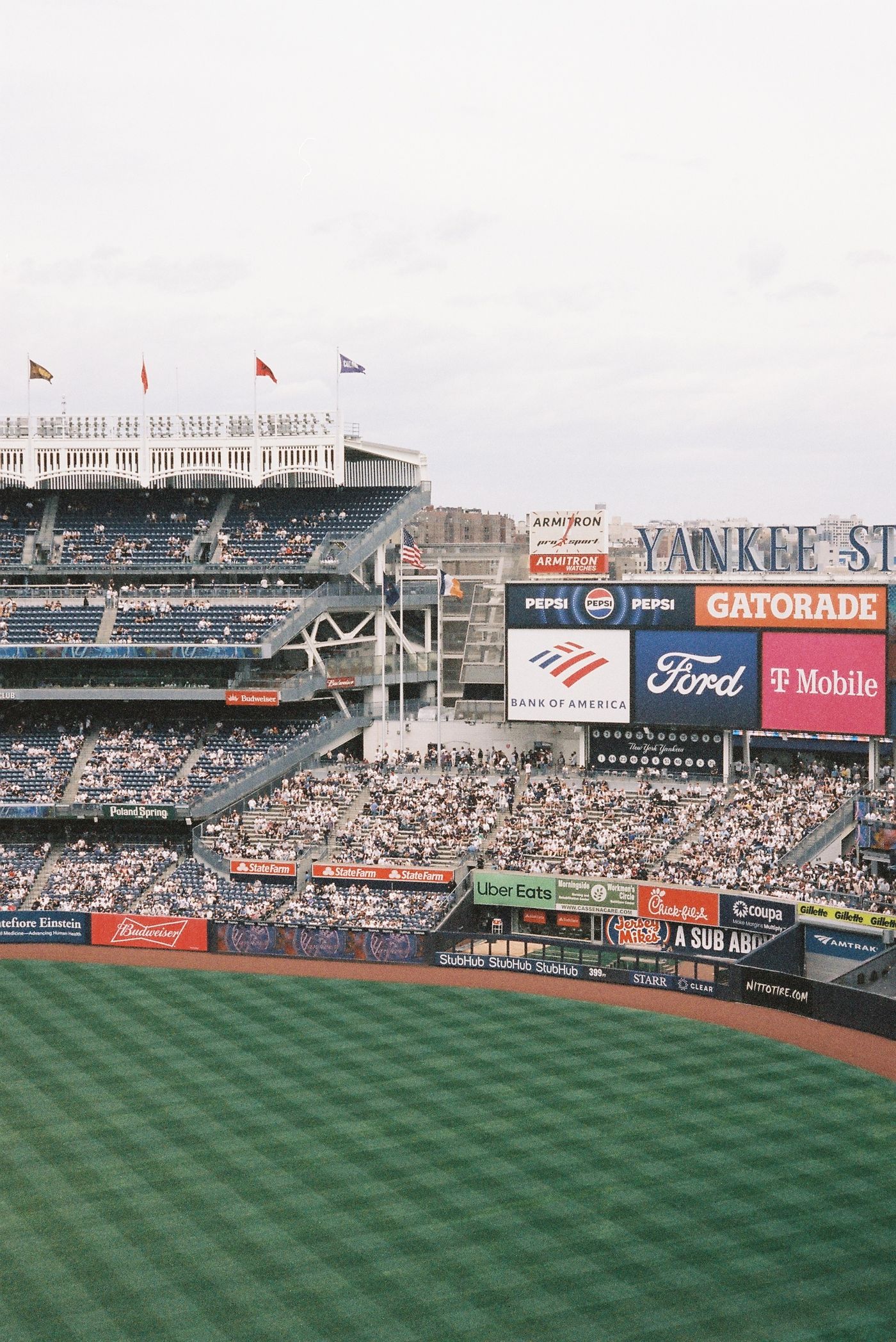 Major league baseball stadium in daylight with tiered seating and outfield advertising boards typical of sports sponsorship inventory