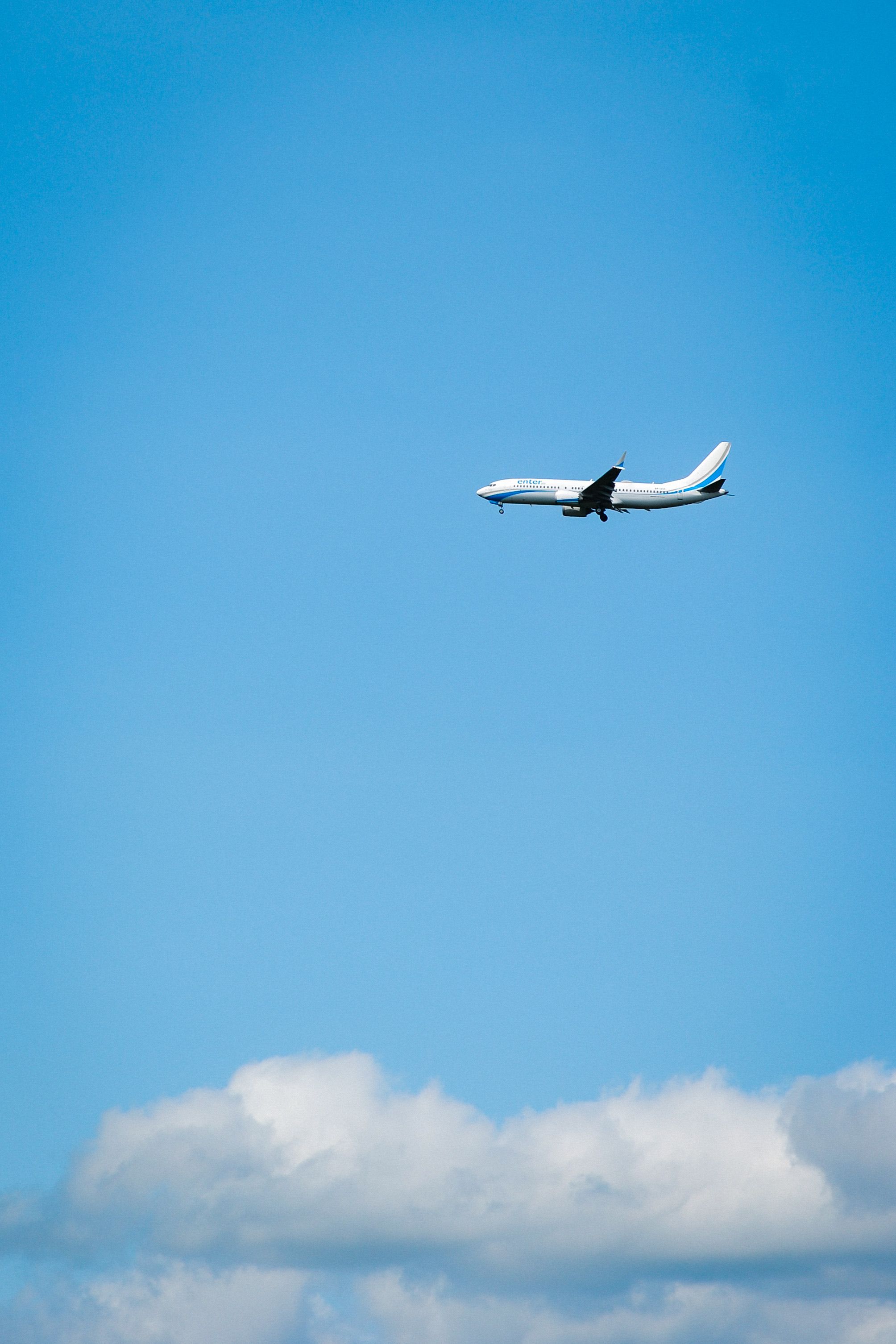 Commercial Airplane Flying Through Clear Blue Sky · Free Stock Photo