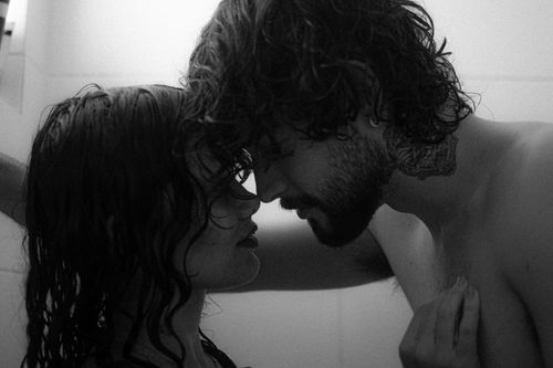 Free Romantic black and white photo of a young couple sharing an intimate moment in the shower. Stock Photo