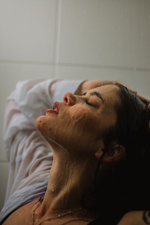 Free A serene close-up of a woman enjoying the shower with a tranquil expression. Stock Photo