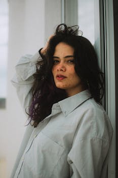 Candid portrait of a young woman with natural hair and freckles, exuding confidence.
