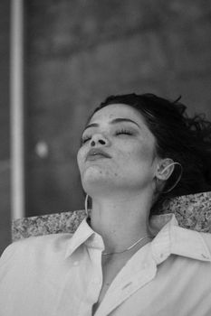 Calm black and white portrait of a woman in a relaxed pose.