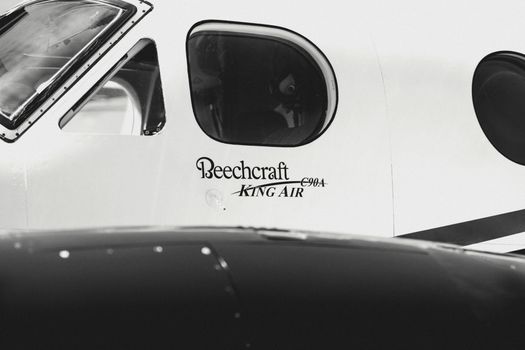 Detailed view of Beechcraft King Air C90A airplane cockpit window in black and white.