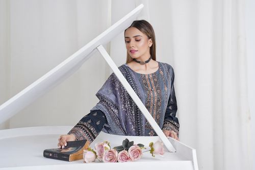 Free A poised fashion model poses indoors with a vintage book and pink roses. Perfect for fashion and lifestyle themes. Stock Photo