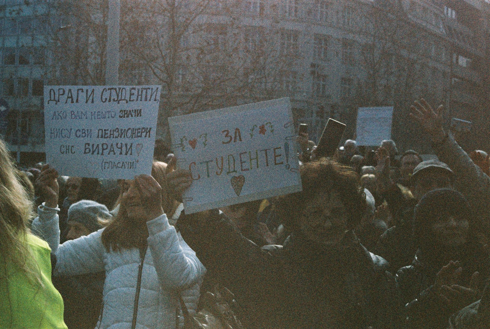 A large group of students holding signs during a peaceful protest outdoors.