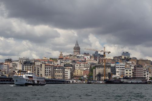 Free Scenic view of Galata Tower and Istanbul skyline under cloudy skies, captured from the water. Stock Photo