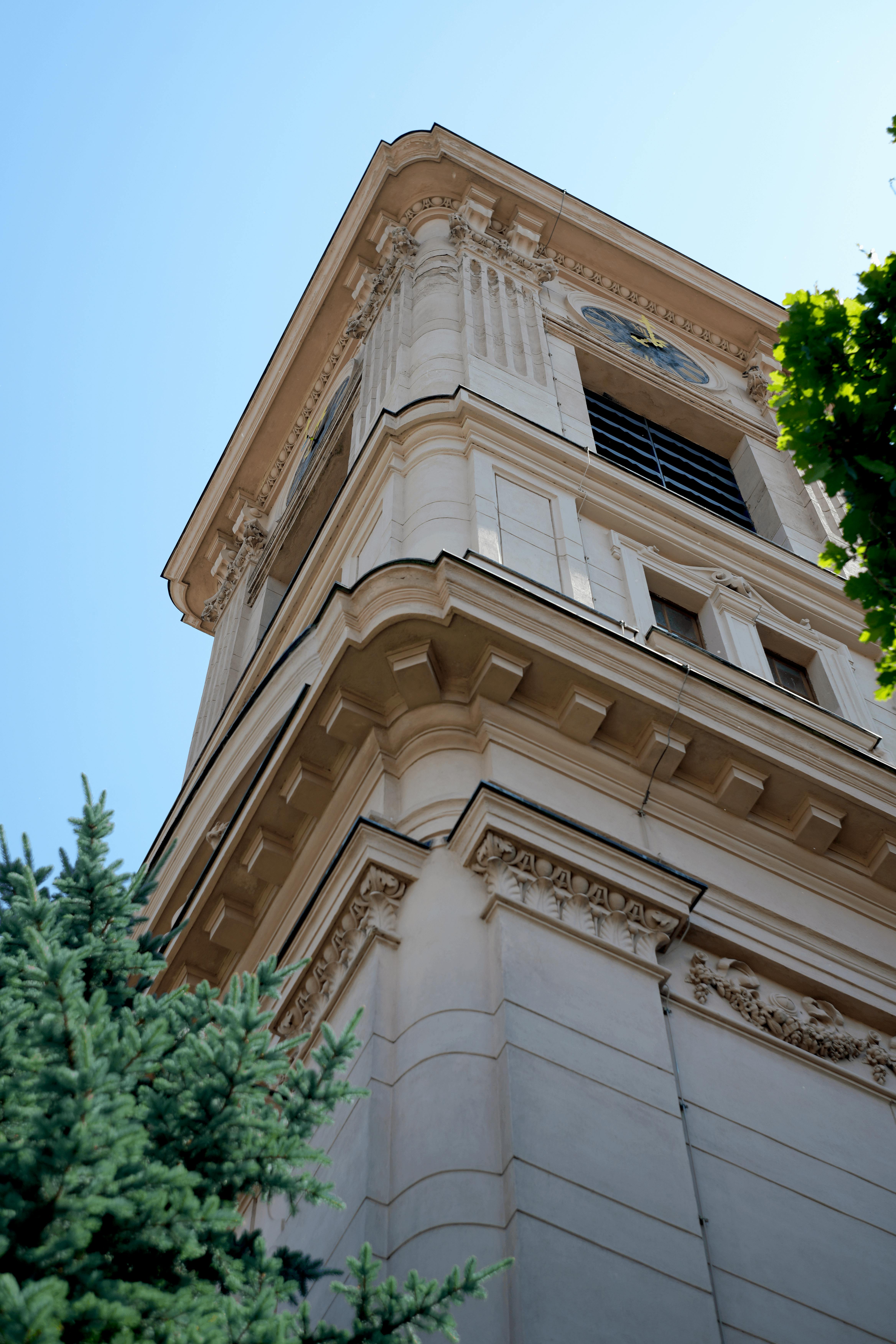 De franc Vista angular ascendent d'una torre del rellotge barroca a Burgenland, Àustria, sota un cel blau clar. Foto d'estoc
