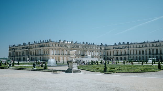 Explore the grandeur of the Palace of Versailles and its meticulously designed gardens on a sunny day in France.