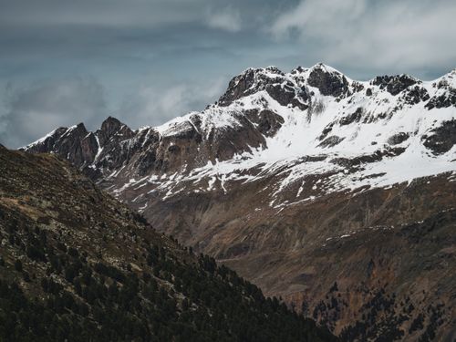 Free Breathtaking view of snow-topped mountains under cloudy skies in Pontresina, Switzerland. Stock Photo