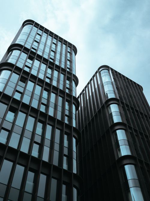 Free Twin towering office buildings with glass facades against a distinctive blue sky. Stock Photo