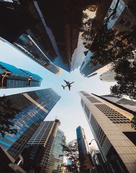 A striking perspective of Singapore's skyline with an airplane flying above. Perfect for travel and urban themes.