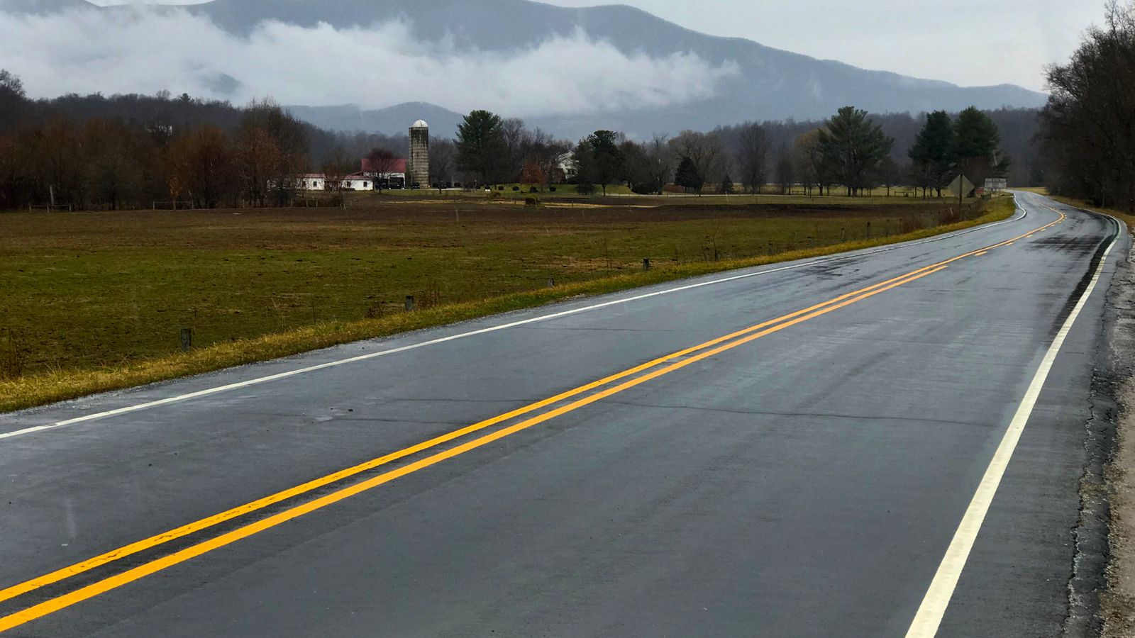 A scenic highway in Massies Mill, Virginia, with misty mountains and a quiet rural landscape.