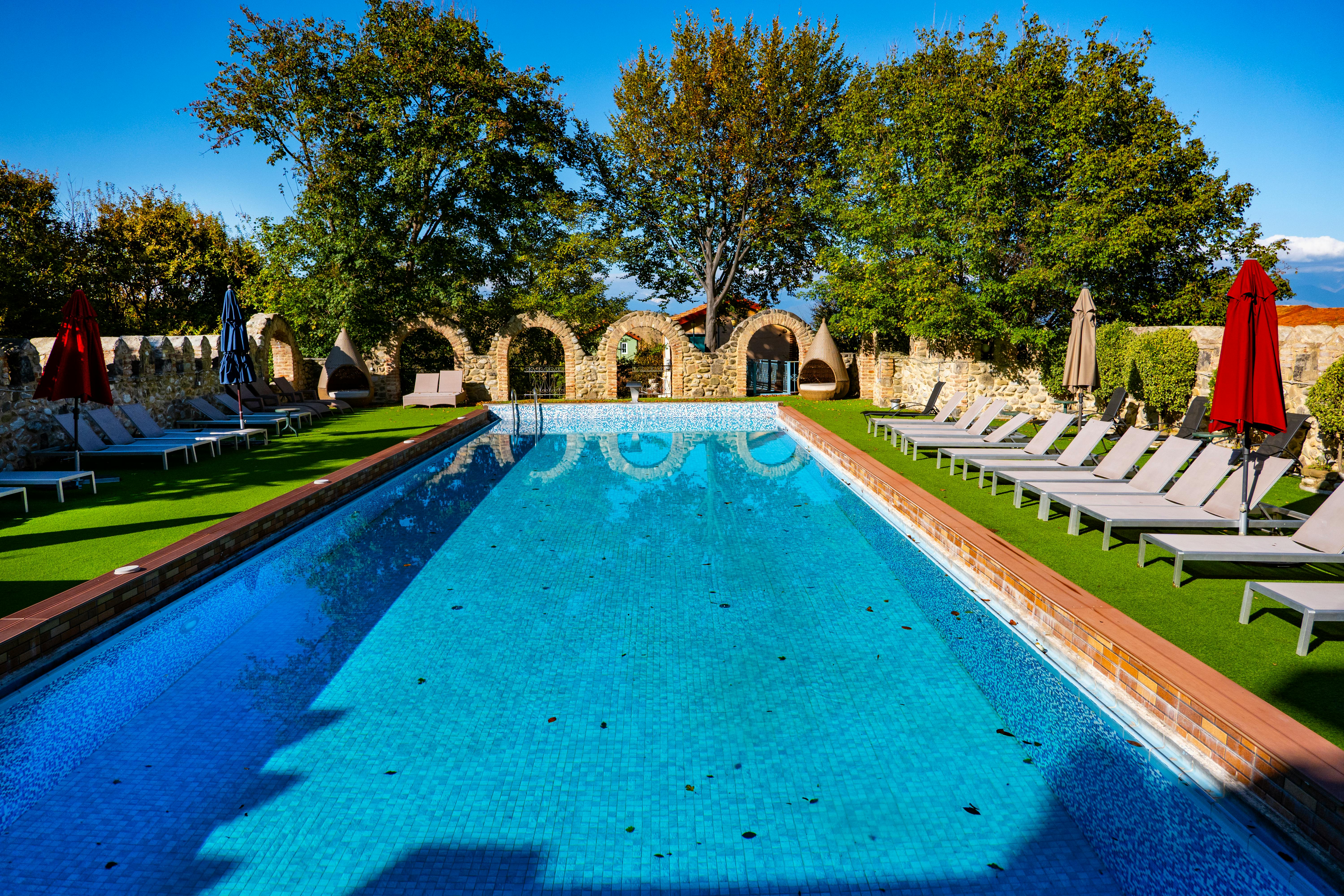 Inviting outdoor swimming pool surrounded by lounge chairs in sunny Telavi, Georgia.
