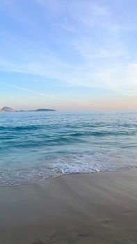 Beautiful sunrise over a tranquil beach with gentle waves and a clear sky. Perfect for relaxation imagery.