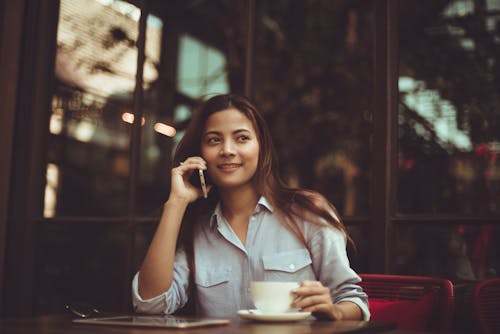 Retrato, De, Mujer Joven, Utilizar, Teléfono Móvil, En, Café